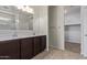 Bathroom featuring double sinks, dark wood cabinets, and a walk-in closet at 2420 E San Borja Trl, Casa Grande, AZ 85194