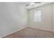 This bedroom offers neutral carpet, a ceiling fan, and a bright window at 2420 E San Borja Trl, Casa Grande, AZ 85194