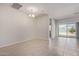 Spacious open-plan living room featuring tile floors, chandelier, and sliding glass doors to the backyard at 2420 E San Borja Trl, Casa Grande, AZ 85194