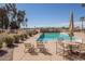 Community pool with chairs, tables, and a lush landscape. Perfect for relaxing and swimming at 2420 E San Borja Trl, Casa Grande, AZ 85194