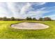 Well-maintained sand trap on a golf course, surrounded by green grass and trees at 2420 E San Borja Trl, Casa Grande, AZ 85194