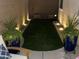 Relaxing backyard with artificial grass, decorative planters, and subtle ground lighting for evening enjoyment at 266 S Eliseo Felix Jr Way, Avondale, AZ 85323