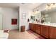 Bathroom featuring double sinks, vanity, large mirror, and a separate tub and shower at 27406 N 22Nd Ln, Phoenix, AZ 85085