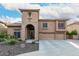 Beautiful home featuring a stone arch entry, three-car garage, and a meticulously maintained front yard at 27406 N 22Nd Ln, Phoenix, AZ 85085