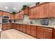 Modern kitchen featuring wood cabinetry, granite countertops, mosaic backsplash, and stainless steel appliances at 27406 N 22Nd Ln, Phoenix, AZ 85085