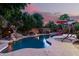 Sparkling pool area with a built-in waterfall, lush greenery and comfortable lounge at 27406 N 22Nd Ln, Phoenix, AZ 85085