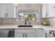 Bright kitchen featuring white cabinets, quartz countertops, and a window with backyard views at 2747 S Brooks --, Mesa, AZ 85202