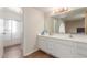 Bathroom with white cabinets, double sinks, and shower with glass door at 28 W Hillside St, Mesa, AZ 85201