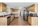 Well-lit kitchen with stainless steel appliances, wood cabinets, and tile floors at 28 W Hillside St, Mesa, AZ 85201