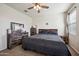 A cozy bedroom features carpet flooring, a ceiling fan, and wood furniture at 30747 W Indianola Ave, Buckeye, AZ 85396