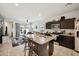 This kitchen features dark cabinets, granite countertops and views of the adjacent open concept living area at 30747 W Indianola Ave, Buckeye, AZ 85396