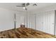 Bright bedroom featuring hardwood floors, a ceiling fan, a closet, and white walls at 324 W Culver St # 2, Phoenix, AZ 85003