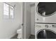 Convenient laundry area featuring a stacked washer and dryer next to a toilet at 324 W Culver St # 2, Phoenix, AZ 85003