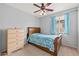 Bedroom with a wooden frame bed, ceiling fan with light fixture, dresser, and a window with blinds at 337 S 172Nd Dr, Goodyear, AZ 85338