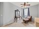 Cozy bedroom featuring a plush chair with ottoman, a charming vanity, and a ceiling fan at 337 S 172Nd Dr, Goodyear, AZ 85338