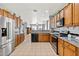 Well-lit kitchen featuring ample wooden cabinetry, granite countertops, stainless appliances, and open layout at 337 S 172Nd Dr, Goodyear, AZ 85338