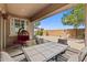 Covered patio with outdoor dining set, chair swing, desert landscape, and exterior block wall at 337 S 172Nd Dr, Goodyear, AZ 85338