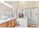 Bright main bathroom featuring a double sink vanity, soaking tub, and glass enclosed shower at 3546 E Latham Way, Gilbert, AZ 85297