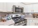 Close up on stainless steel oven, microwave, and gray backsplash in the well appointed kitchen at 3546 E Latham Way, Gilbert, AZ 85297