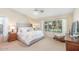 Serene primary bedroom with a luxurious upholstered headboard, plush carpeting, and a large window at 3546 E Latham Way, Gilbert, AZ 85297