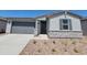 Well-maintained single-story home featuring a gray garage door, stone accents, neutral stucco, and desert landscaping at 3764 N Camden Dr, Florence, AZ 85132