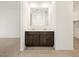 Bathroom with dual vanity sinks, dark cabinets, large mirror and wood flooring at 3864 N Camden Dr, Florence, AZ 85132