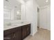 Bathroom featuring dual vanity sinks, dark cabinets and a big mirror at 3864 N Camden Dr, Florence, AZ 85132