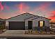 Charming single-story home featuring stucco, a two-car garage, and a desert-landscaped front yard under a colorful sunset sky at 3864 N Camden Dr, Florence, AZ 85132