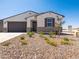Lovely single-story home featuring desert landscaping with vibrant yellow flowers, enhancing its curb appeal and modern design at 3864 N Camden Dr, Florence, AZ 85132