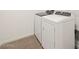 New white laundry machines sit ready in the laundry room with clean laminate flooring at 3864 N Camden Dr, Florence, AZ 85132