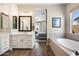 Bright bathroom with double vanity, soaking tub, wood-look tile flooring, and stylish decor at 4097 E Tonto Pl, Chandler, AZ 85249