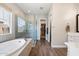 Modern bathroom featuring a soaking tub, glass shower, and access to a spacious walk-in closet at 4097 E Tonto Pl, Chandler, AZ 85249