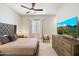 Comfortable bedroom with a ceiling fan, large window, and a mounted television for relaxation at 4097 E Tonto Pl, Chandler, AZ 85249