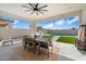 Inviting covered patio has ceiling fan and overlooks outdoor kitchen, pool, and artificial turf at 4097 E Tonto Pl, Chandler, AZ 85249