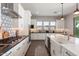 Modern kitchen featuring a large island, black countertops, white cabinets, and stainless steel appliances at 4097 E Tonto Pl, Chandler, AZ 85249