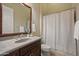 Neutral-toned bathroom featuring a granite countertop, wood vanity, and a shower with a white curtain at 41413 N Club Pointe Dr, Anthem, AZ 85086