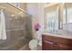 Bathroom featuring a glass-enclosed shower, pink orchids and wood vanity with cultured marble countertop at 41413 N Club Pointe Dr, Anthem, AZ 85086