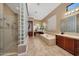 This primary bath features glass block walls, a large tub and shower with dual shower heads at 41413 N Club Pointe Dr, Anthem, AZ 85086