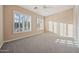 Light-filled bedroom with neutral walls, plush carpet, white trim, and plantation shutters on the windows at 41413 N Club Pointe Dr, Anthem, AZ 85086