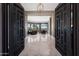 Grand foyer featuring marble floors, black wood doors and an open view to the living and dining spaces at 41413 N Club Pointe Dr, Anthem, AZ 85086