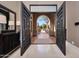 Bright foyer featuring marble floors and black wood doors leading to a serene courtyard at 41413 N Club Pointe Dr, Anthem, AZ 85086