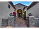 Elegant front entrance with stone pillars, stylish planters, and a beautifully designed dark wood door at 41413 N Club Pointe Dr, Anthem, AZ 85086