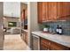 Kitchen wet bar featuring granite countertop, a beverage refrigerator, and custom wood cabinets at 41413 N Club Pointe Dr, Anthem, AZ 85086