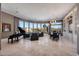 Spacious living room with curved windows showcasing desert views, a piano, and elegant furnishings at 41413 N Club Pointe Dr, Anthem, AZ 85086