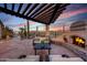 Stylish outdoor area with fireplace, pergola, and desert landscaping, perfect for entertaining and enjoying the outdoors at 41413 N Club Pointe Dr, Anthem, AZ 85086