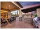 Serene covered patio featuring a built-in grill, stone accents, and ample space for relaxation and entertaining at 41413 N Club Pointe Dr, Anthem, AZ 85086