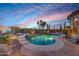 A backyard pool illuminated at dusk with desert landscaping and mountain views at 41413 N Club Pointe Dr, Anthem, AZ 85086