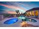 A backyard with pool, spa, and desert landscaping illuminated in the evening at 41413 N Club Pointe Dr, Anthem, AZ 85086