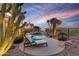 A backyard pool with lounge chairs, desert landscaping, and evening lighting at 41413 N Club Pointe Dr, Anthem, AZ 85086