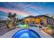 A backyard pool and spa featuring evening lights and desert landscaping at 41413 N Club Pointe Dr, Anthem, AZ 85086